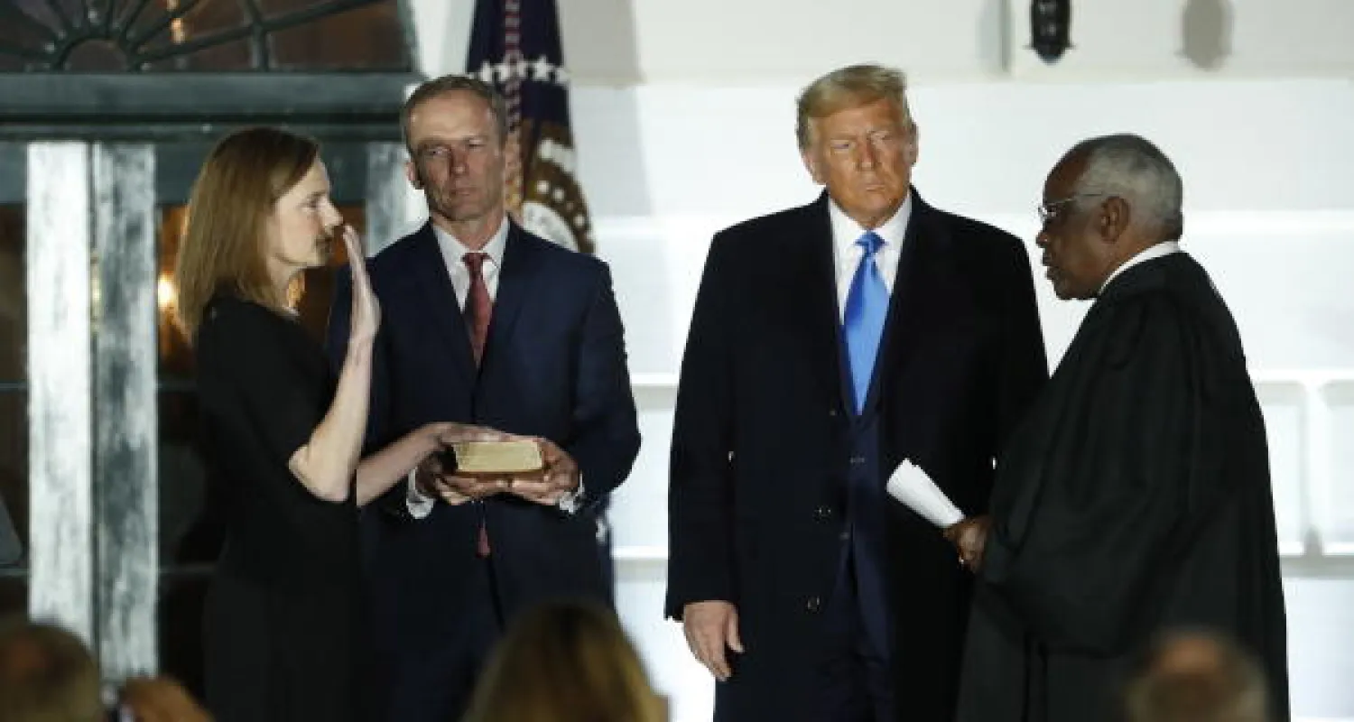 القاضية إيمي كوني باريت تؤدي قسم اليمين أمام عضو المحكمة العليا القاضي كلارنس توماس في حضور الرئيس دونالد ترمب (إ.ب.أ)