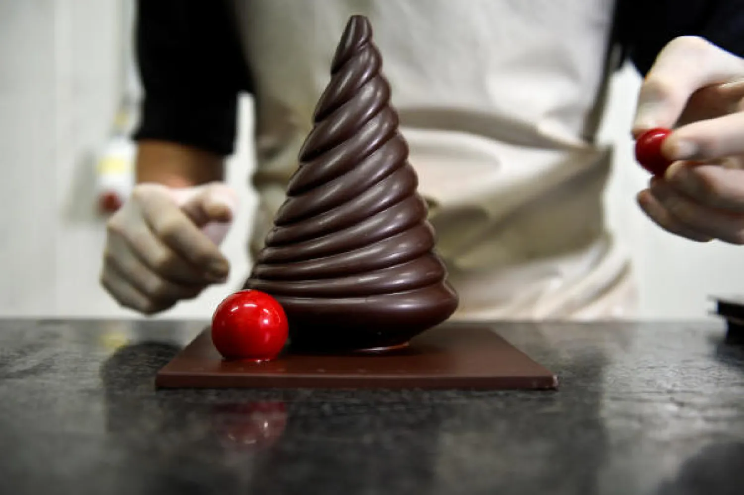 A worker prepares a pastry at the workshop of Belgian chocolate maker Marcolini, in Brussels, Belgium October 27, 2020. (Reuters)