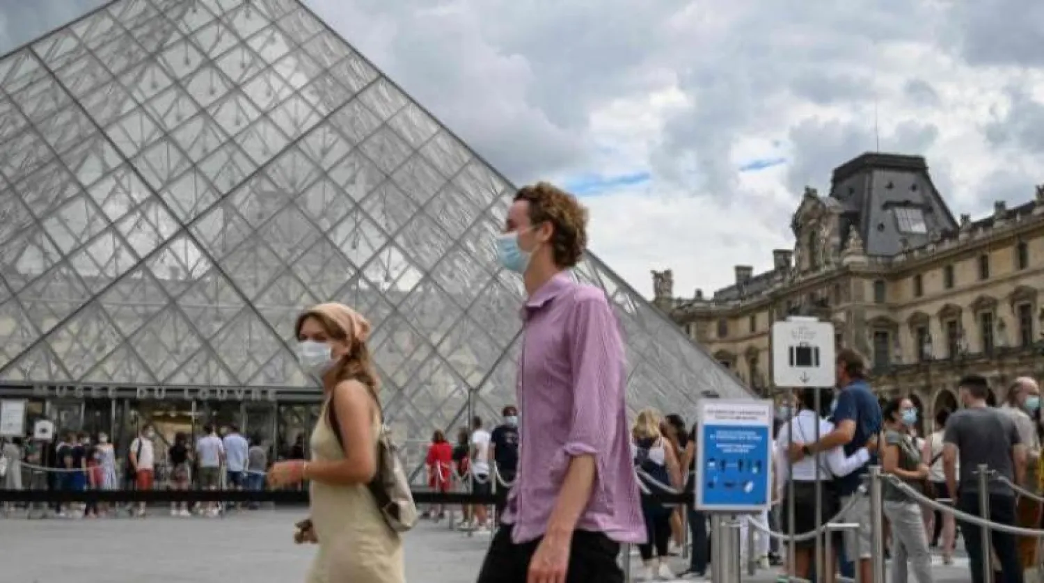 سيّاح يضعون كمامات قرب متحف اللوفر في باريس (أ.ف.ب)