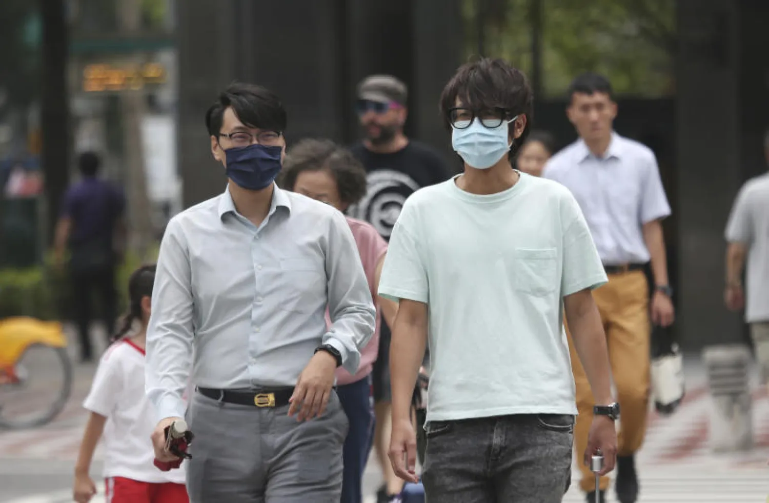 مواطنان يرتديان كمامتين في أحد شوارع تايوان (أ.ب)