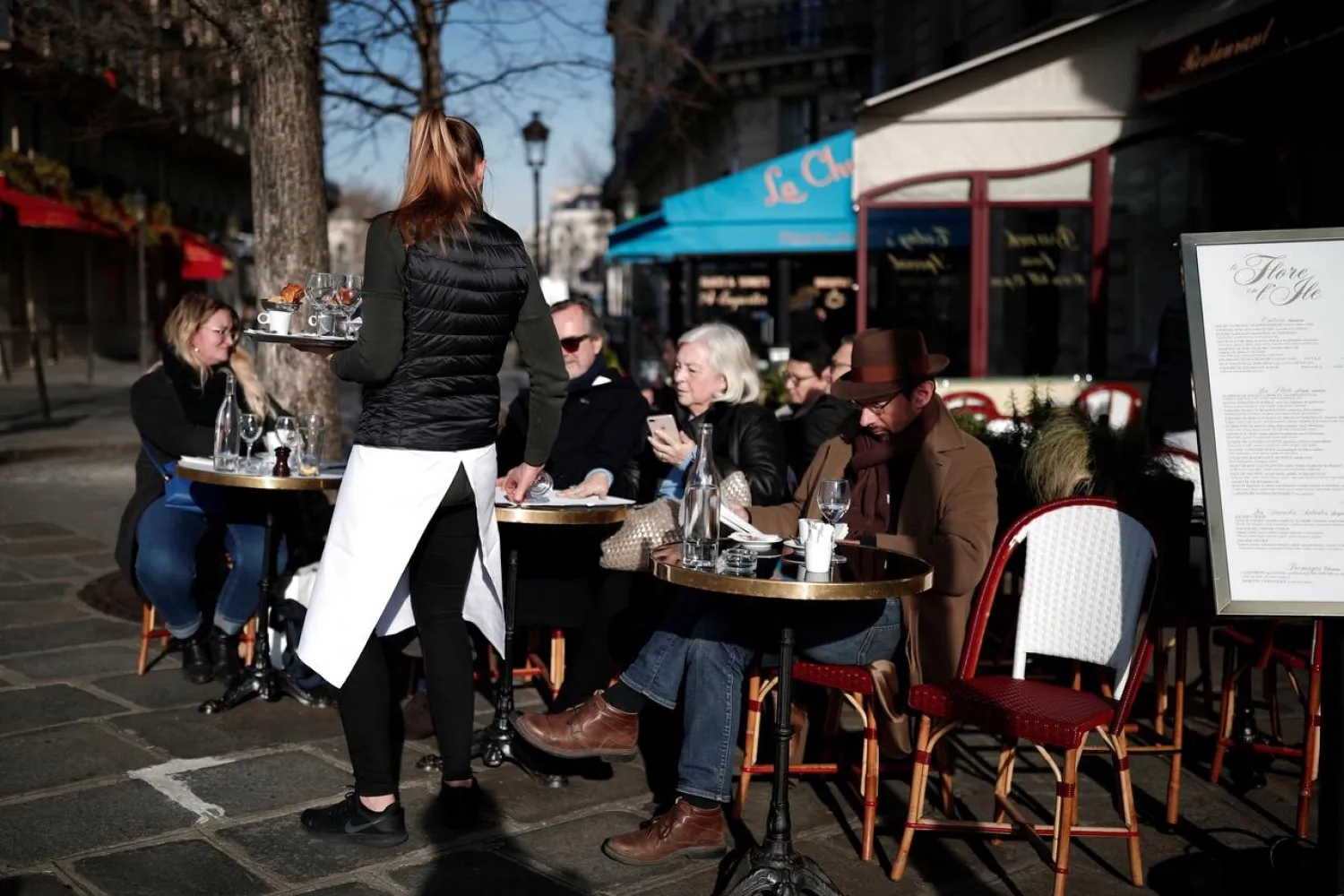 FILE PHOTO: Tourists and residents sit in the sun at a cafe terrace in Paris, France, February 13, 2019. REUTERS/Benoit Tessier
