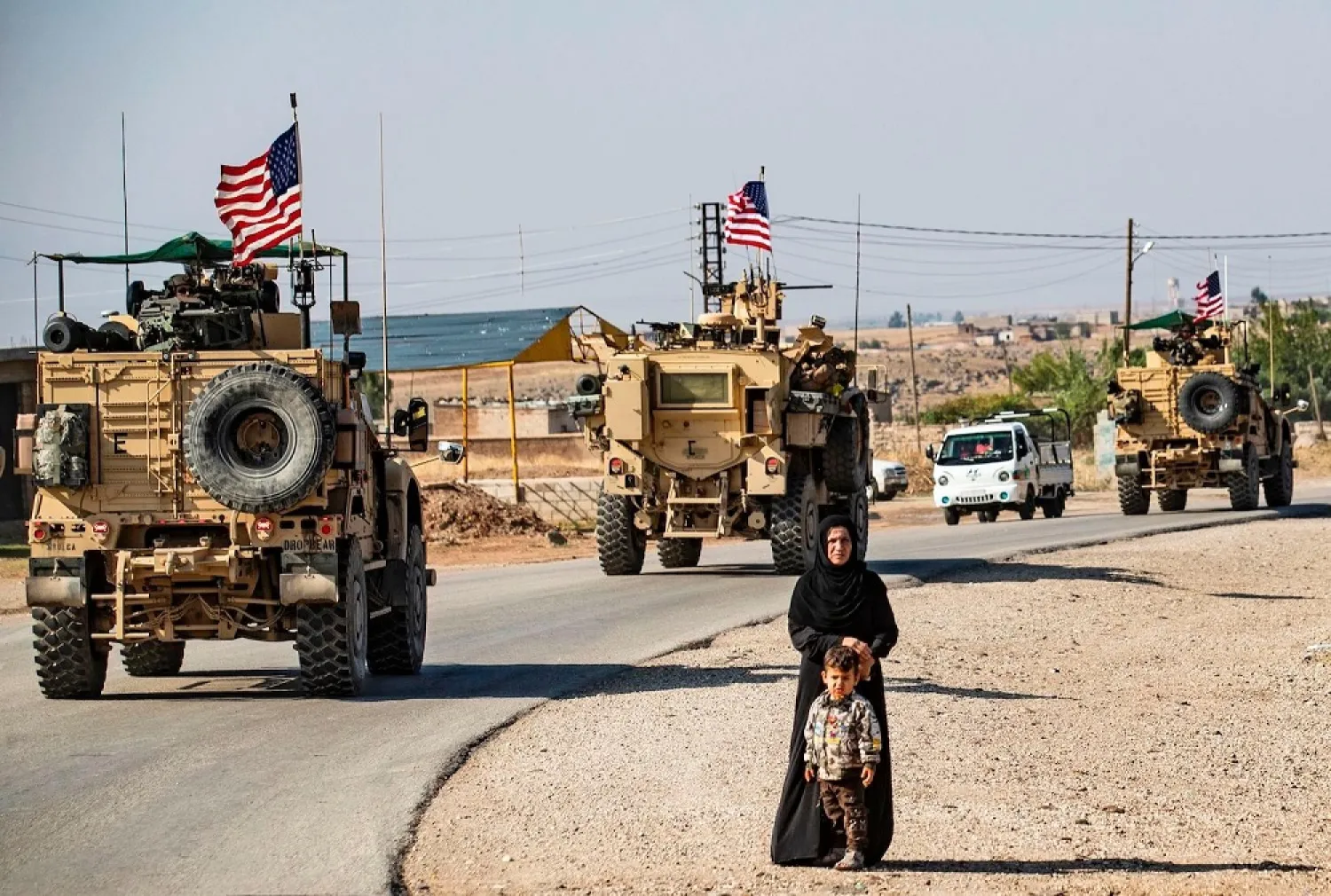 A convoy of US armored vehicles patrols the northeastern Syrian town of Qahtaniyah at the border with Turkey. (Getty Images)