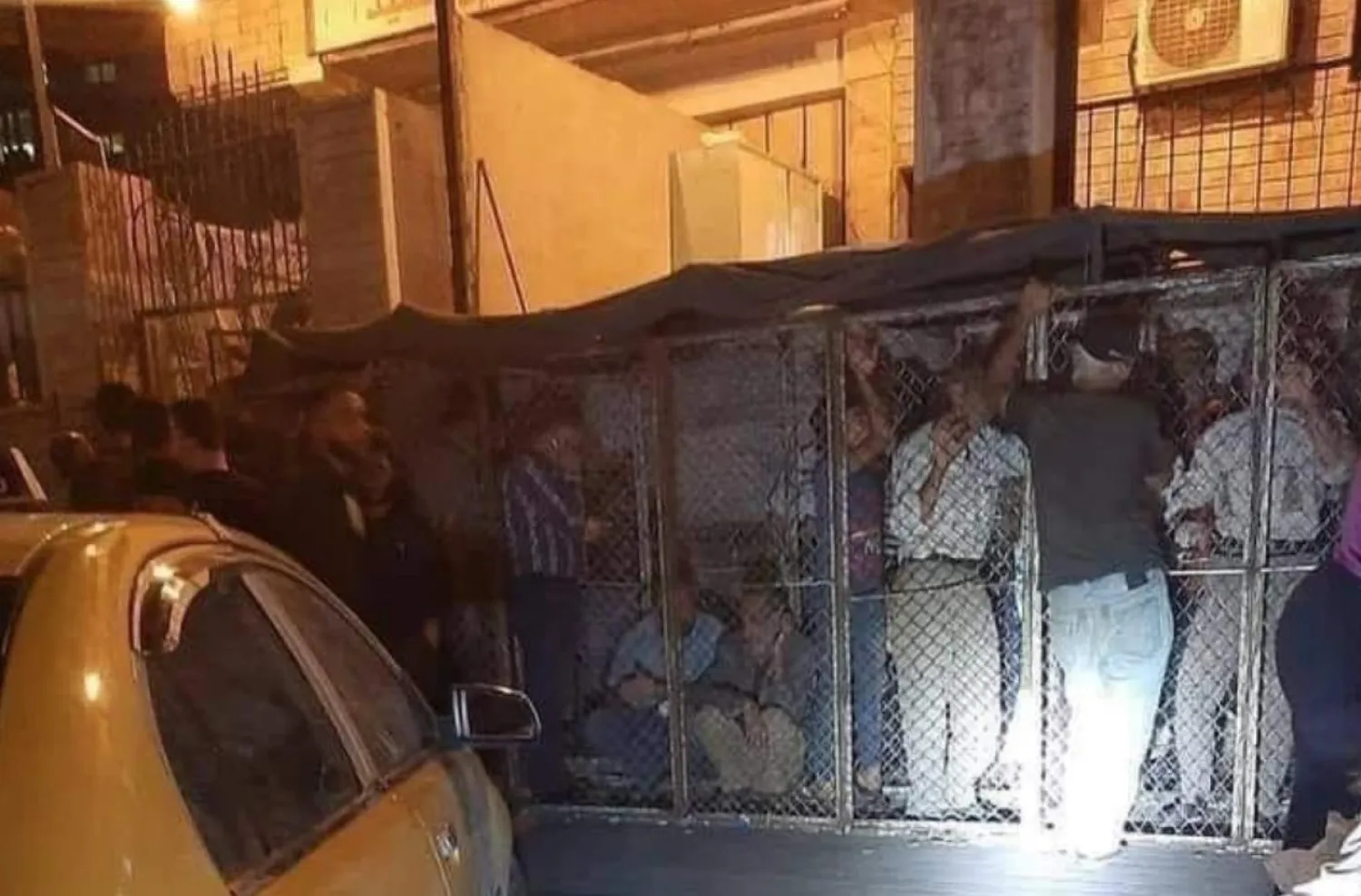 Men seen in iron cages. The images have sparked anger online. (Screengrab/Twitter)