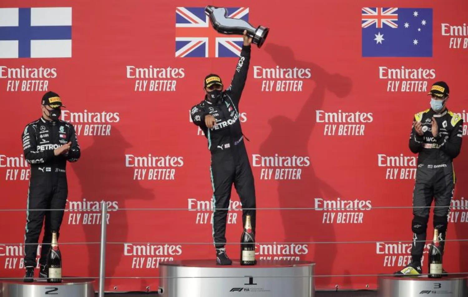 لويس هاميلتون (في المنتصف) وفالتيري بوتاس (يسار) ودانيال ريكياردو (أ.ف.ب)