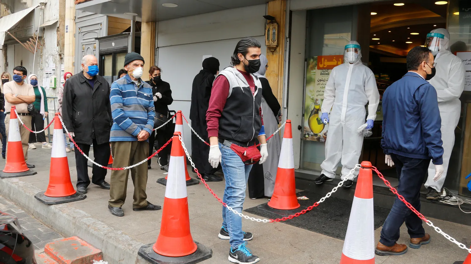 Customers wearing face masks and gloves queue outside a supermarket, during a lockdown to prevent the spread of coronavirus disease (COVID-19) in Beirut, Lebanon, April 6, 2020.  Photo by REUTERS/Mohamed Azakir.

