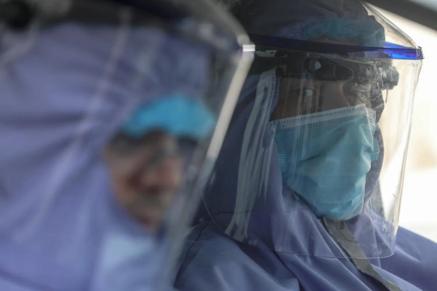 موظفون يرتدون الأقنعة الواقية في غزة (إ.ب.أ)