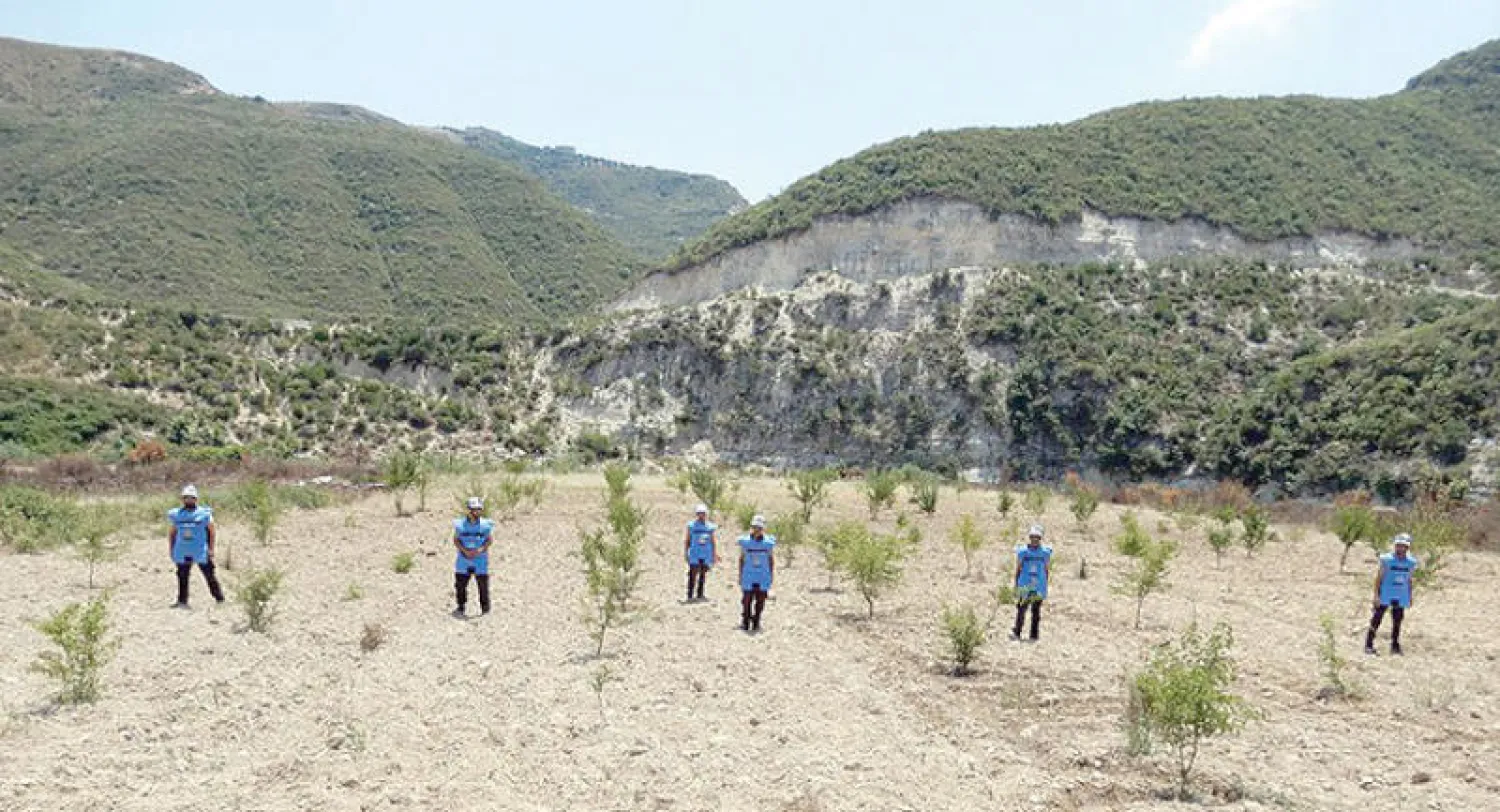 الخوذ البيضاء لعزل الألغام في جسر الشغور بريف إدلب... وفي الكادر متطوع يضع علامة خطر لمنع السكان من الاقتراب (موقع الدفاع المدني)