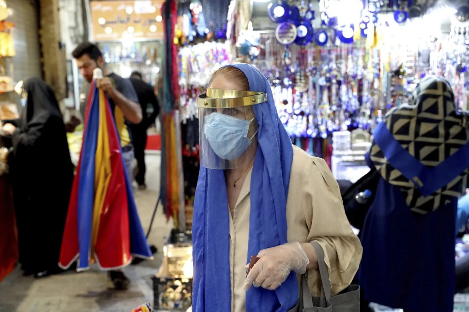 A woman wearing a protective face mask and gloves to help prevent the spread of the coronavirus walks through the Tajrish bazaar in northern Tehran, Iran, Oct. 15, 2020. (AP)