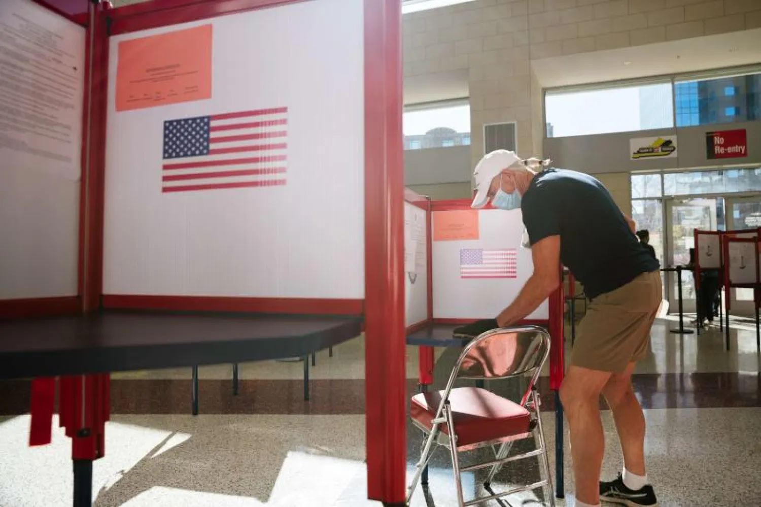 مسؤول انتخابي يعقم صندوق الاقتراع في منطقة الاقتراع في ولاية كنتاكي (أ.ف.ب)