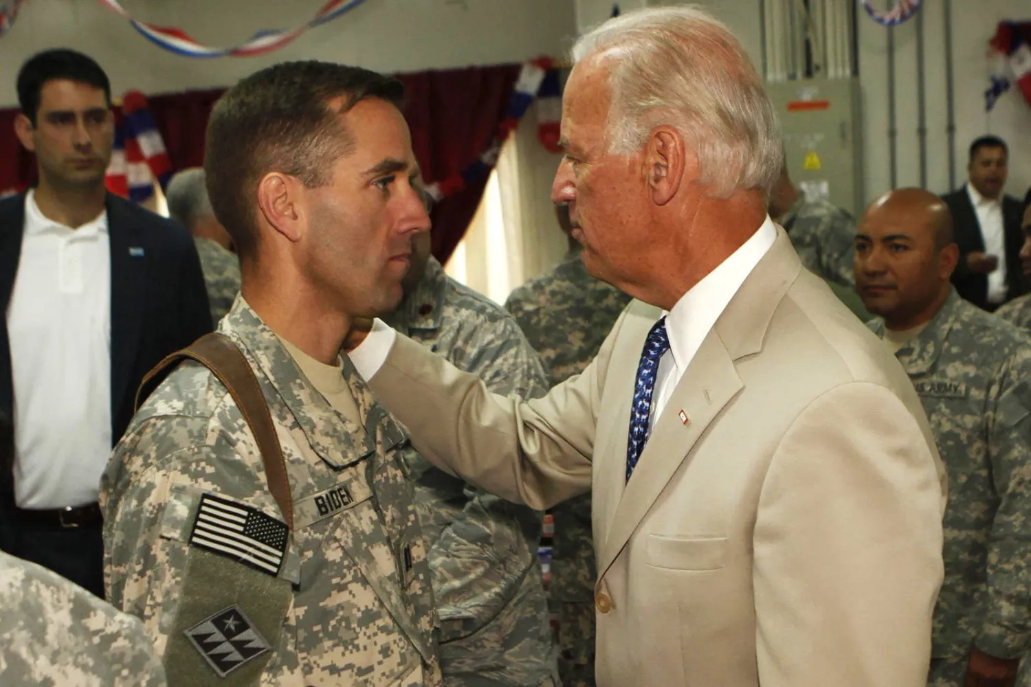 بايدن يتحدث لنجله بيو بايدن، النقيب في الجيش الأميركي، في معسكر النصر خارج بغداد في يوليو (تموز) 2009. (أ.ف.ب)