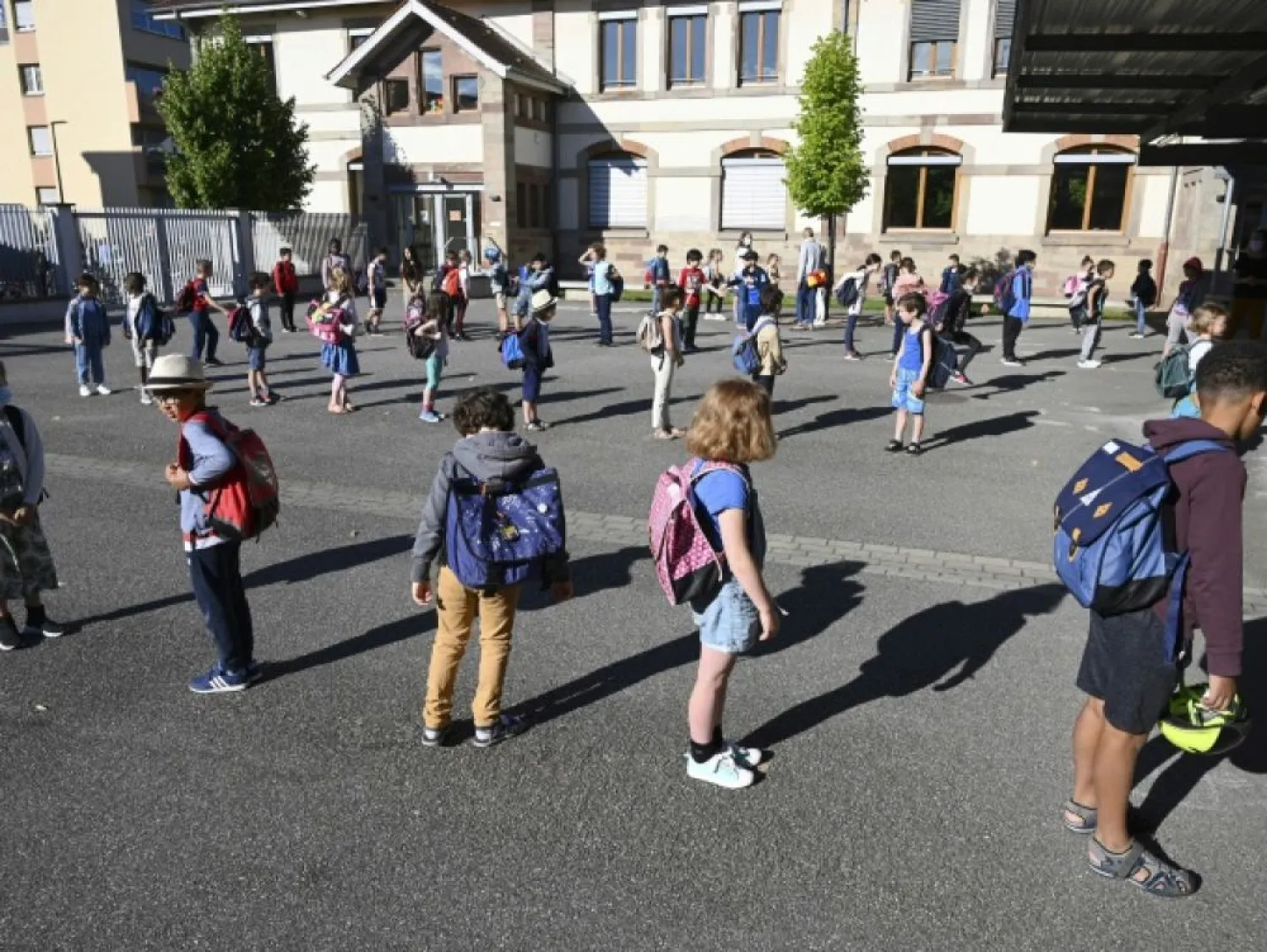 Children queue to enter their classrooms at the Ziegelau elementary school in Strasbourg, eastern France, as primary and middle schools reopen on June 22, 2020. AFP - FREDERICK FLORIN