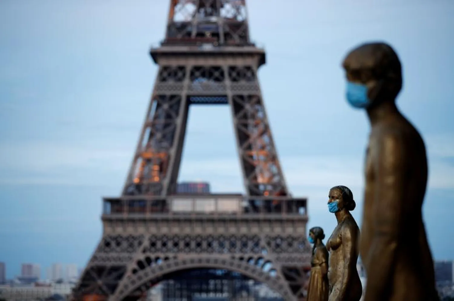 FILE PHOTO: Golden Statues at the Trocadero square near the Eiffel tower wear protective masks during the outbreak of the coronavirus disease (COVID-19) in Paris, France, May 2, 2020. REUTERS/Benoit Tessier


