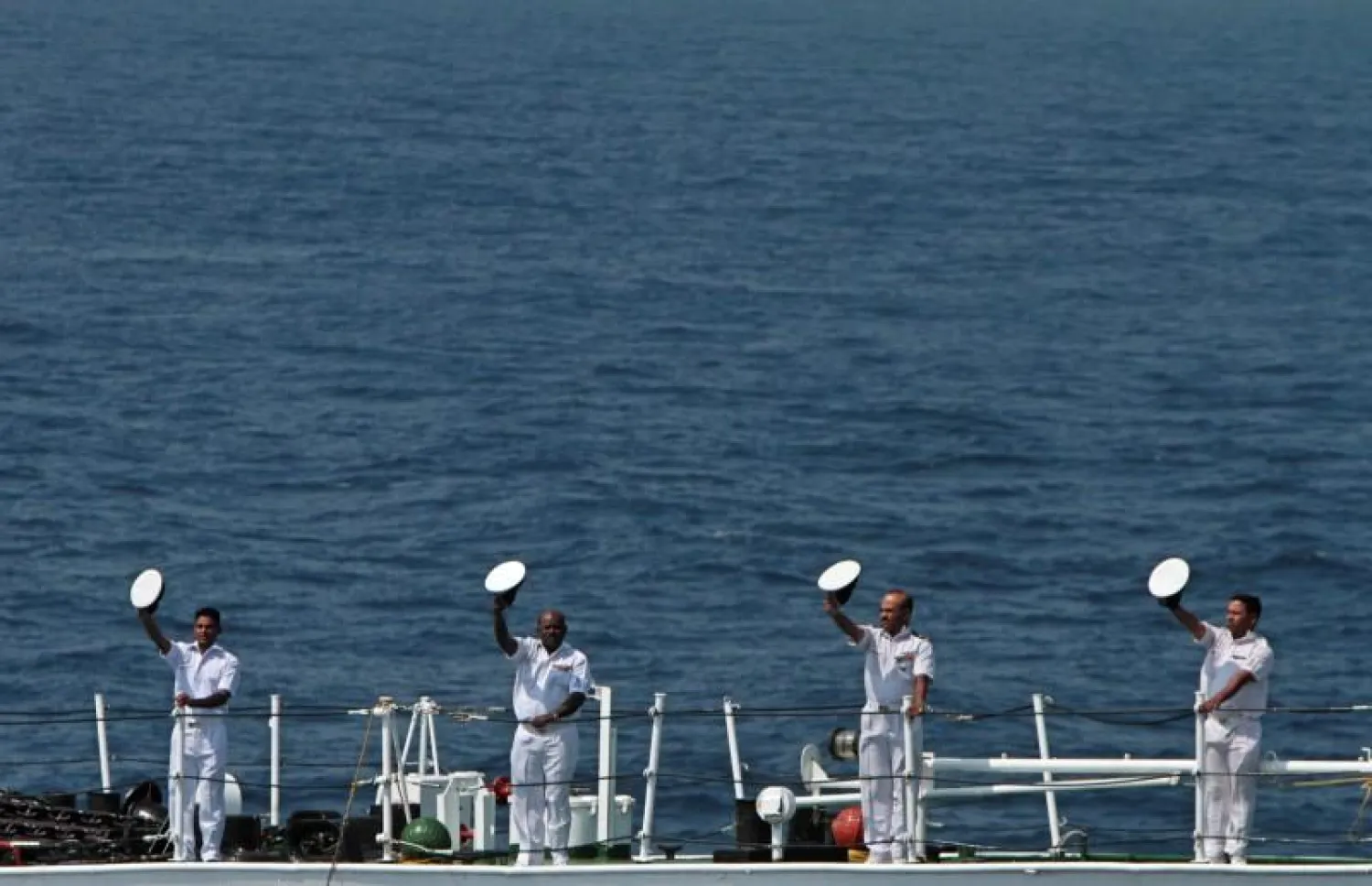 Members of the Indian Coast Guard hold their caps to salute to their Japanese counterparts from the deck of a ship during an Indo-Japan joint coast guard exercise in the waters of the Bay of Bengal, in Chennai January 29, 2012. REUTERS/Babu/Files
