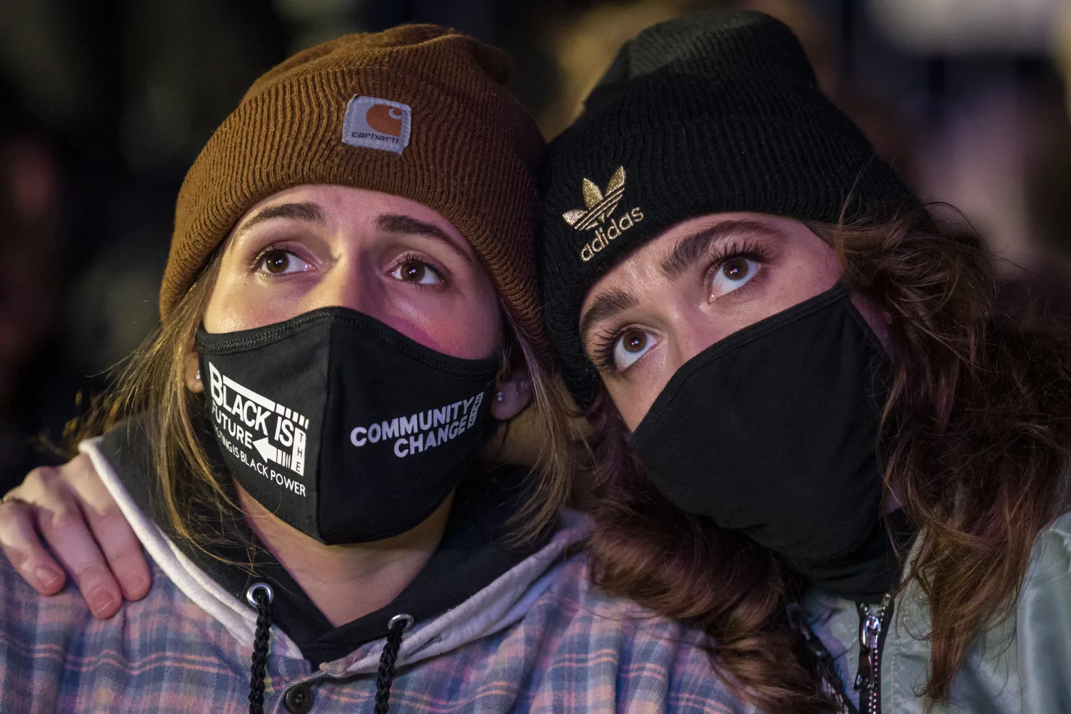 شانون آينشتاين (يسار) وبيكا كارلسون (من أنصار جو بايدن) يشاهدان بث نتائج الانتخابات على شاشة كبيرة في ميدان «ماكفرسون» بالقرب من البيت الأبيض في العاصمة واشنطن (إ.ب.أ)