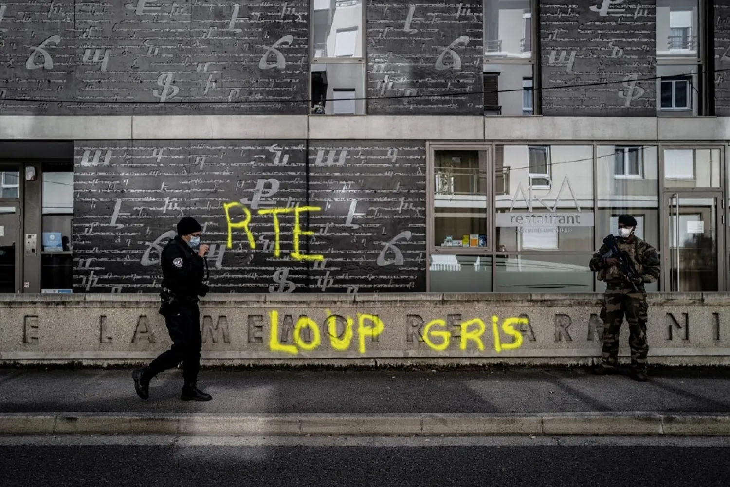 A French army soldier stands guard as a police officer walks by outside the defaced National Armenian Memorial Center in Decines-Charpieu, near Lyon, on November 1, 2020. (AFP)