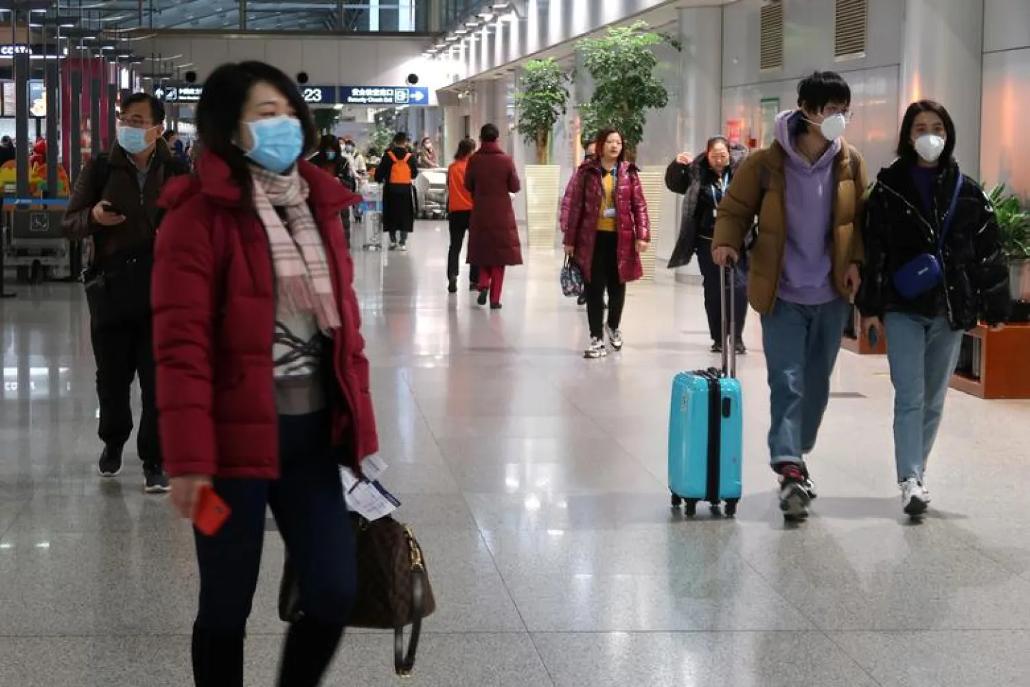 Passengers wearing masks are seen at the terminal hall of the Beijing Capital International Airport, in Beijing, China January 23, 2020. REUTERS/Martin Pollard