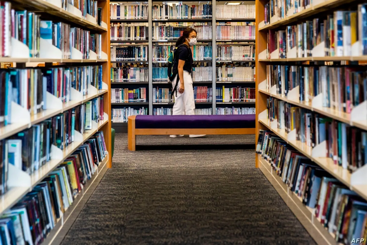 A women looks at books in a public library in Hong Kong on July 4, 2020. AFP