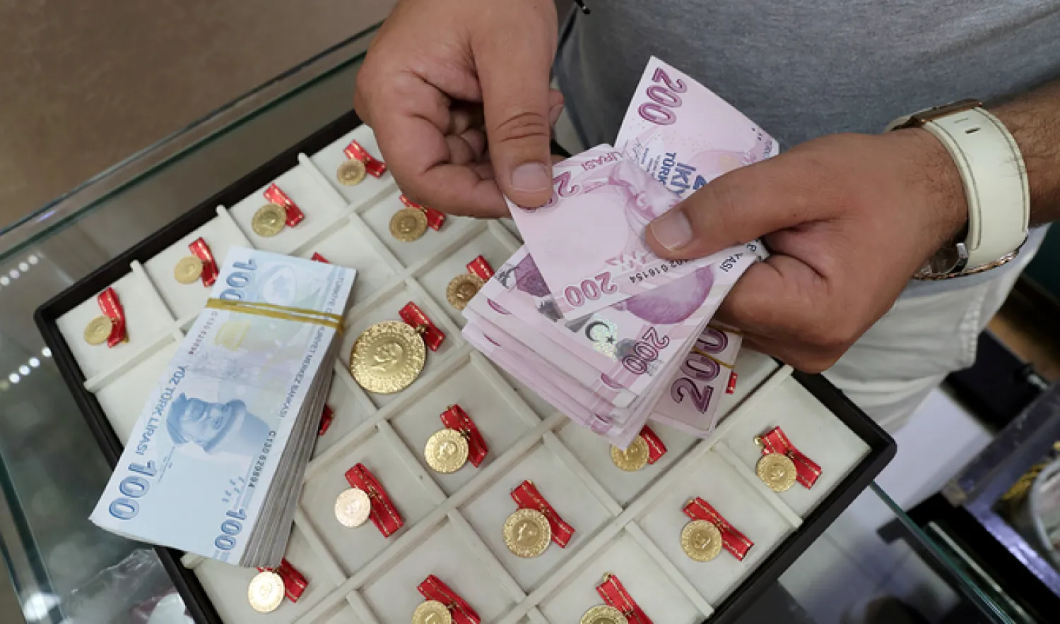 A gold dealer counts Turkish lira banknotes at his shop at the Grand Bazaar in Istanbul, Turkey. Reuters
