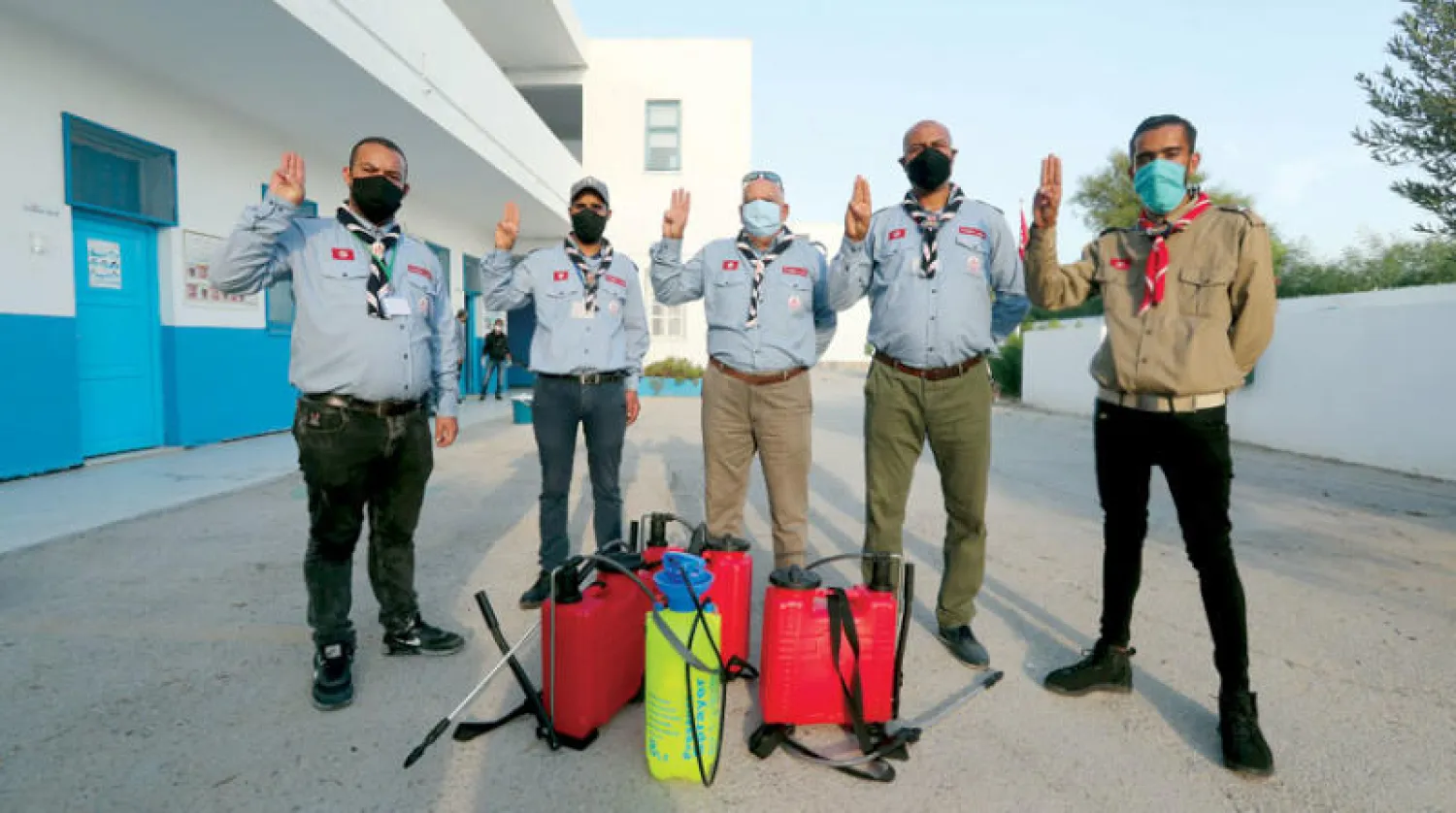 متطوعون يعقمون مدرسة ابتدائية في تونس (إ.ب.أ)