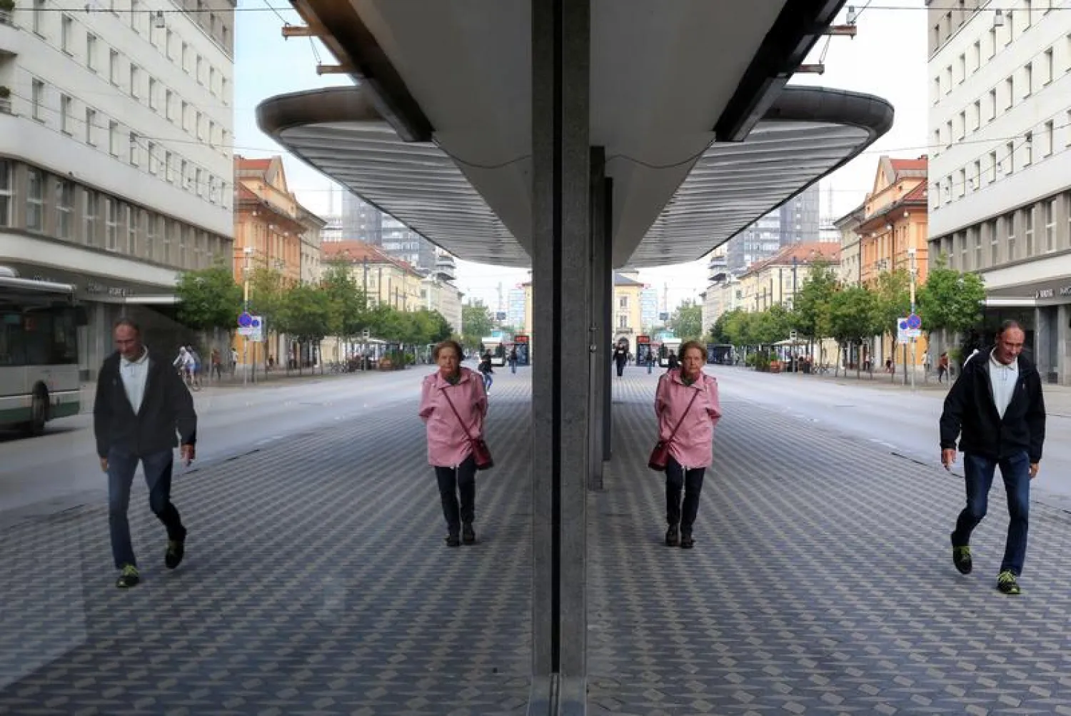 FILE PHOTO: Pedestrians are reflected in the window as they walk on the street, after the Slovenian government called an official end to its coronavirus disease (COVID-19) epidemic, in Ljubljana, Slovenia, May 15, 2020. REUTERS/Borut Zivulovic/File Photo
