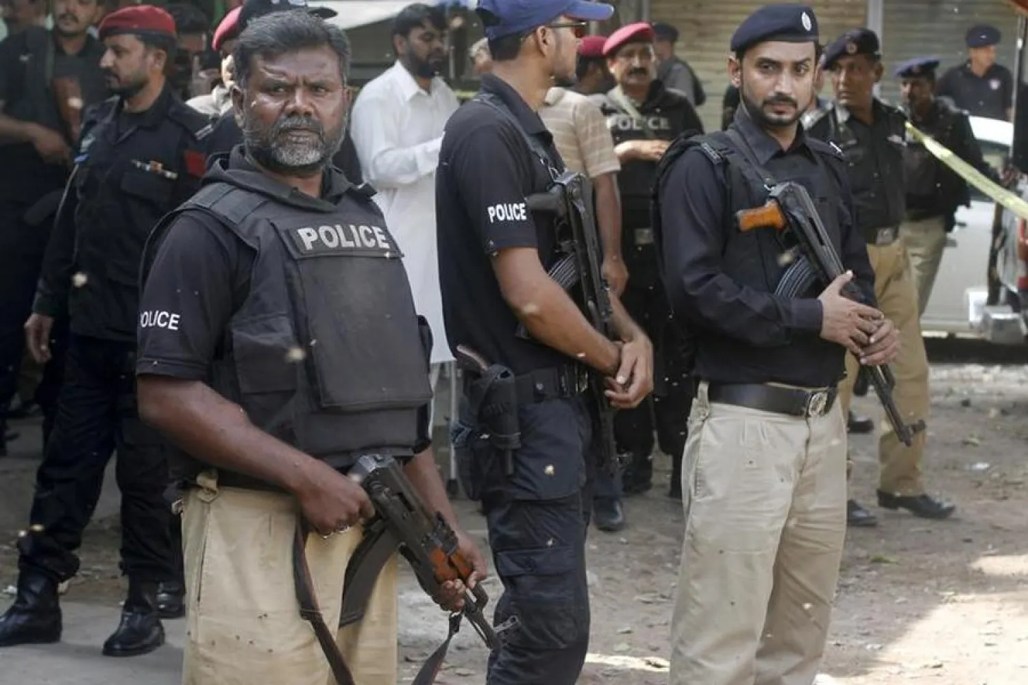 FILE: Policemen stand guard outside while others investigate a shooting at a restaurant in Karachi, Pakistan, August 12, 2015. REUTERS/Athar Hussain

