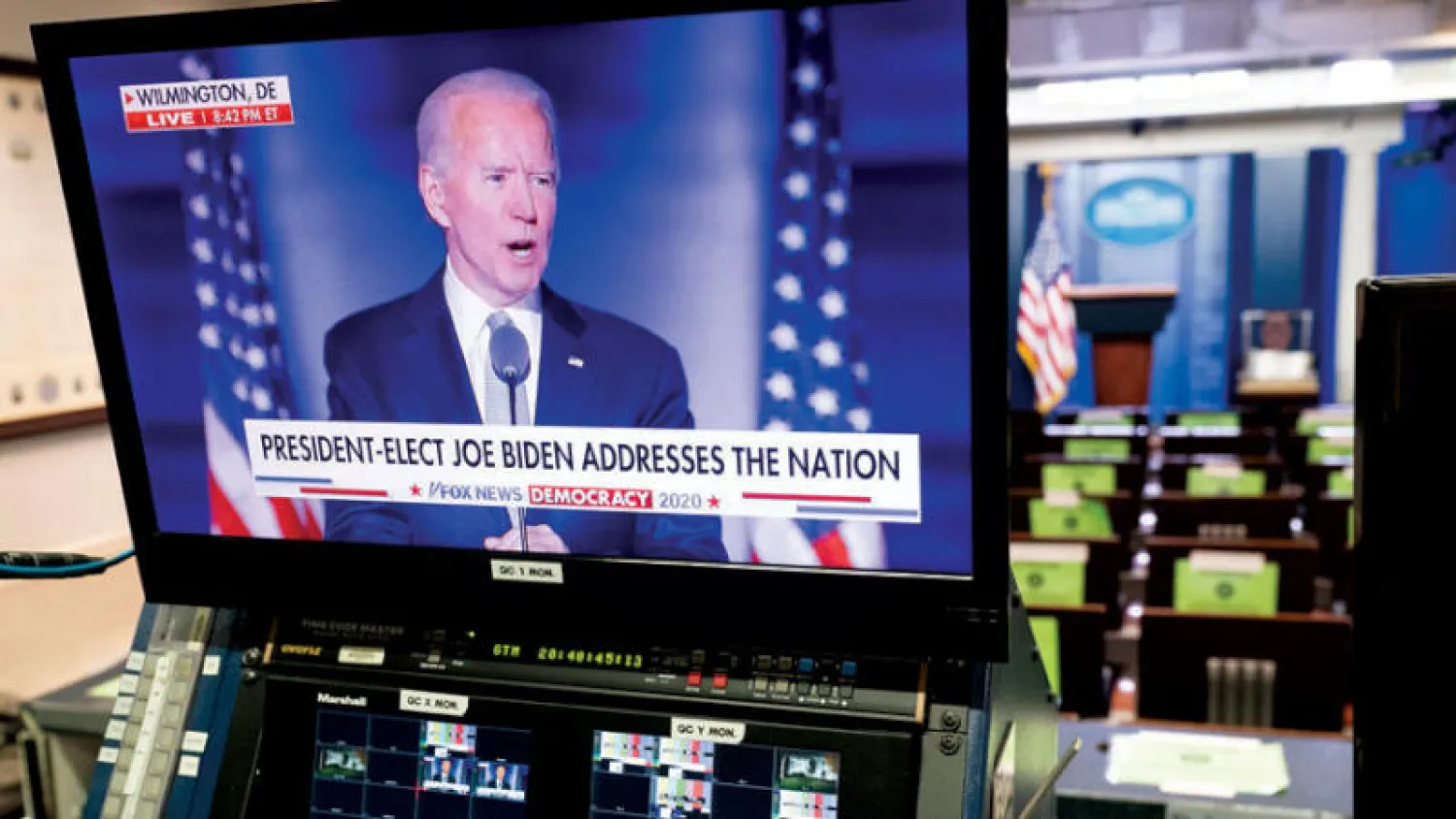 شاشة تنقل خطاب نصر بايدن في غرفة المؤتمرات بالبيت الأبيض مساء السبت (إ.ب.أ)