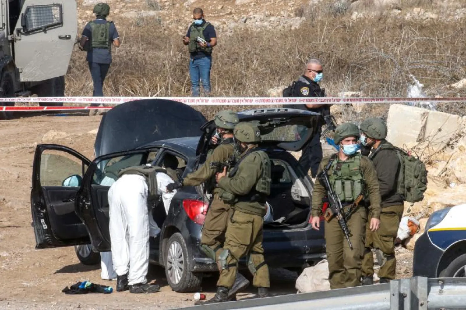 القوات الإسرائيلية تفتش سيارة فلسطيني يشتبه بمحاولته تنفيذ عملية طعن قرب الخليل (أ.ف.ب)