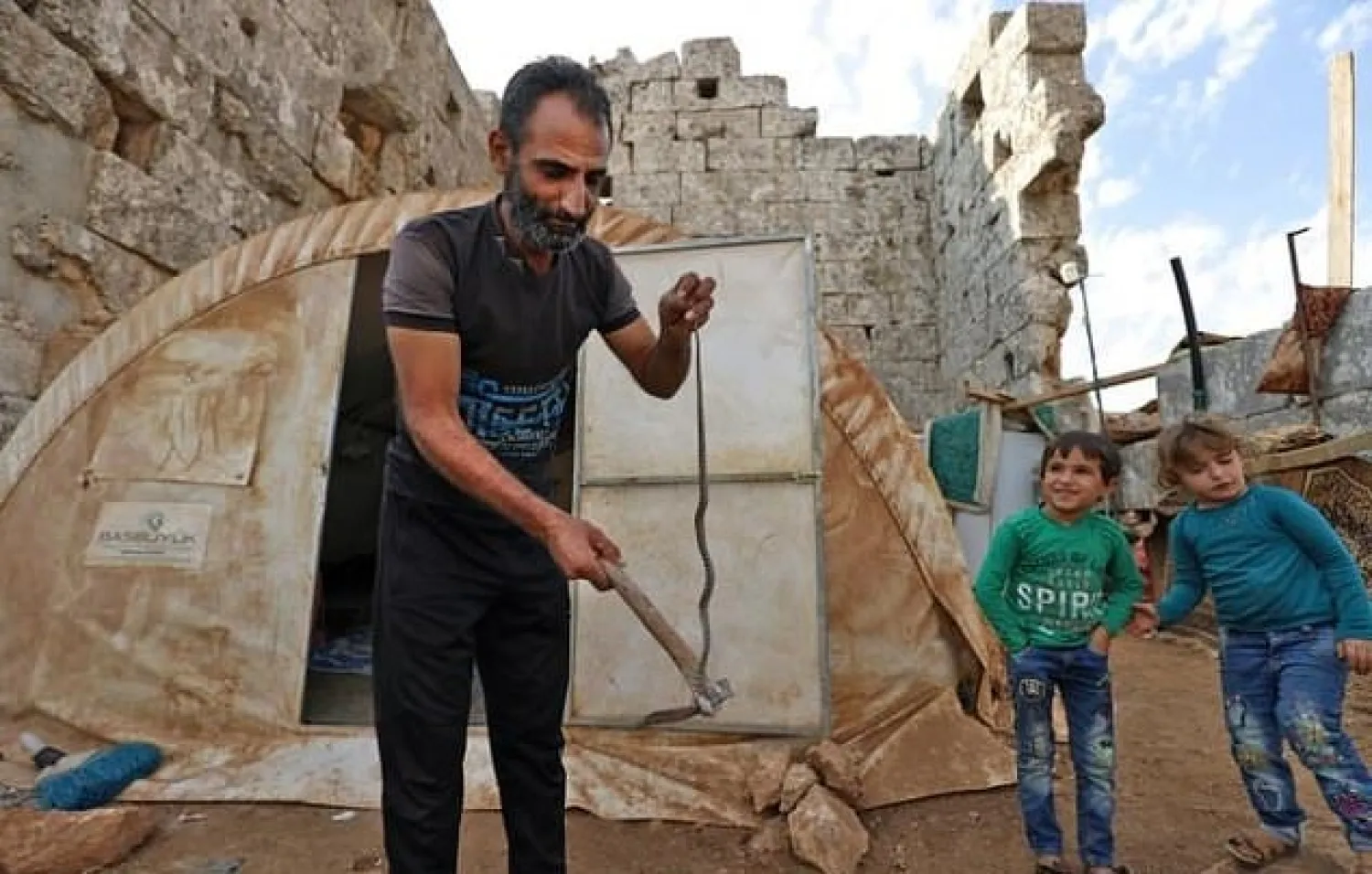 Displaced Syrians live in a makeshift camp amid Roman ruins in the area of Baqirha not far from the Turkish border. AFP