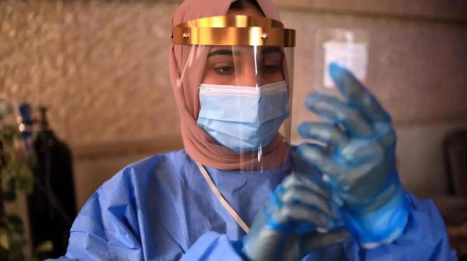 ممرضة عراقية تعدّ حقنة بمنزل مريض بـ«كورونا» في أربيل (أ.ف.ب)