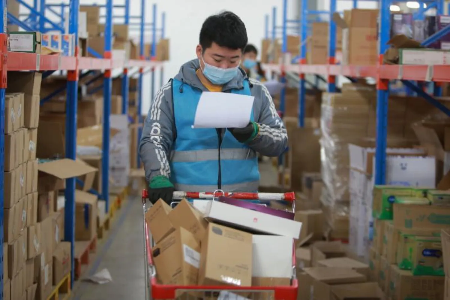 موظف يرتدي الكمامة للوقاية من كورونا في أحد المصانع بالصين (أ.ف.ب)