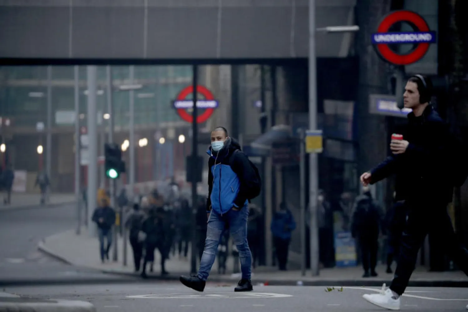 أشخاص يسيرون قرب جسر لندن بعد تطبيق الإغلاق العام (أ.ب)