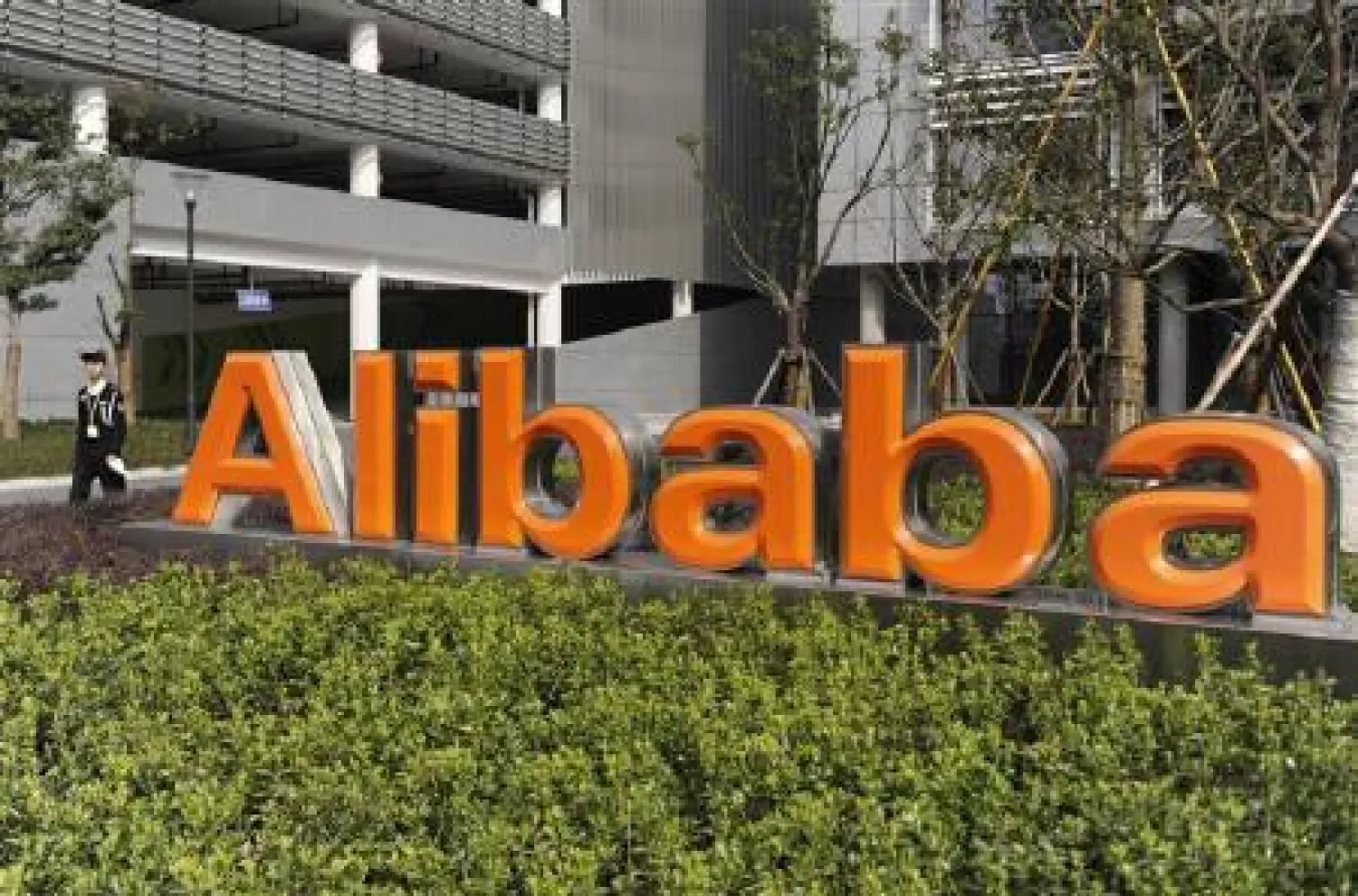 A security guard walks past a logo of Alibaba (China) Technology Co. Ltd at its headquarters on the outskirts of Hangzhou, Zhejiang province March 16, 2010. REUTERS/Lang Lang/Files
