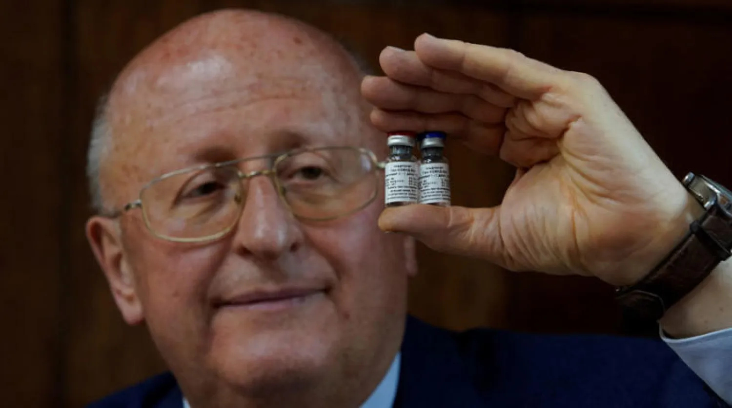 مدير المركز القومي الروسي لبحوث علم الأوبئة والأحياء الدقيقة ألكسندر جينتسبرغ يحمل اللقاح (رويترز)