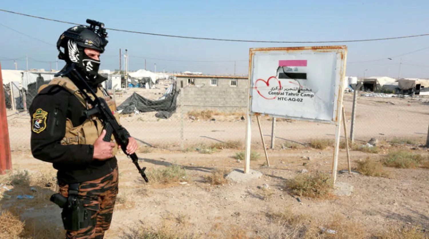 شرطي عراقي قرب مخيم خاوٍ للنازحين في الفالوجة خلال العمليات ضد «داعش» أمس (إ.ب.أ)