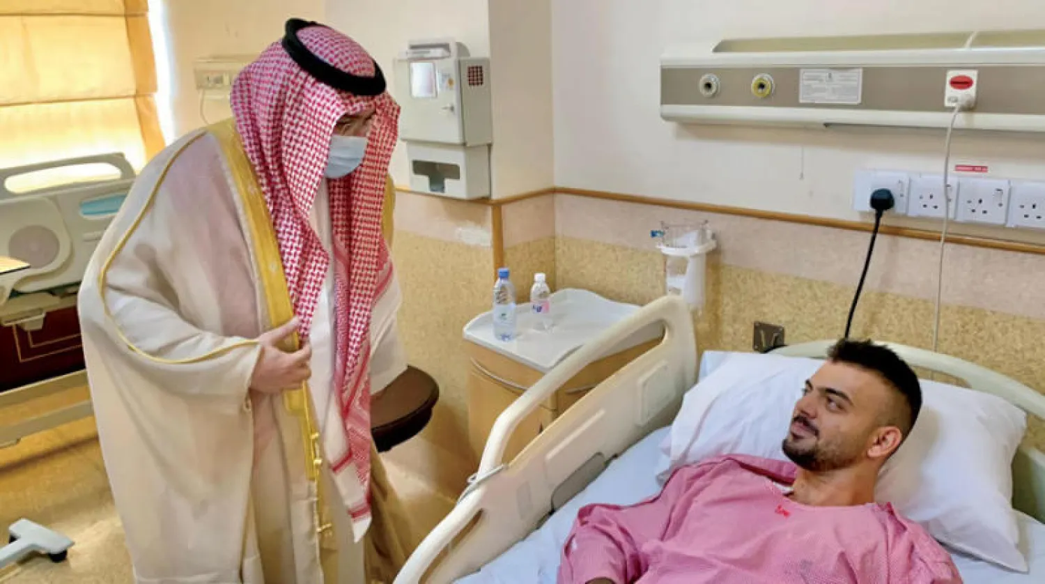 الأمير مشعل بن ماجد لدى زيارته أحد المصابين (واس)