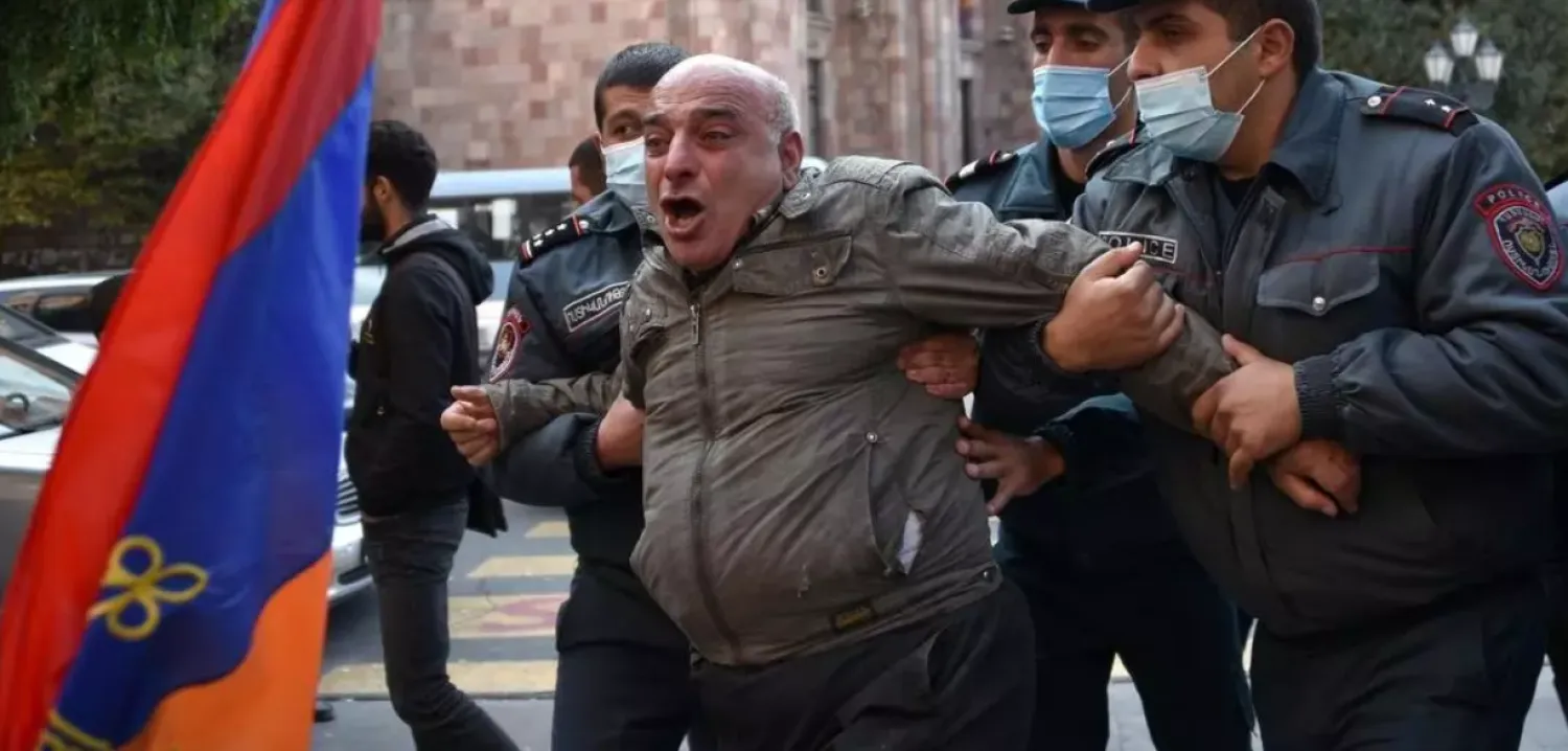 Armenian police officers detain a protestor near the Government building after a protest against the country's agreement to end fighting with Azerbaijan over the disputed Nagorno-Karabakh region outside the government headquarters in Yerevan on November 10, 2020. (Photo by Karen MINASYAN / AFP)
