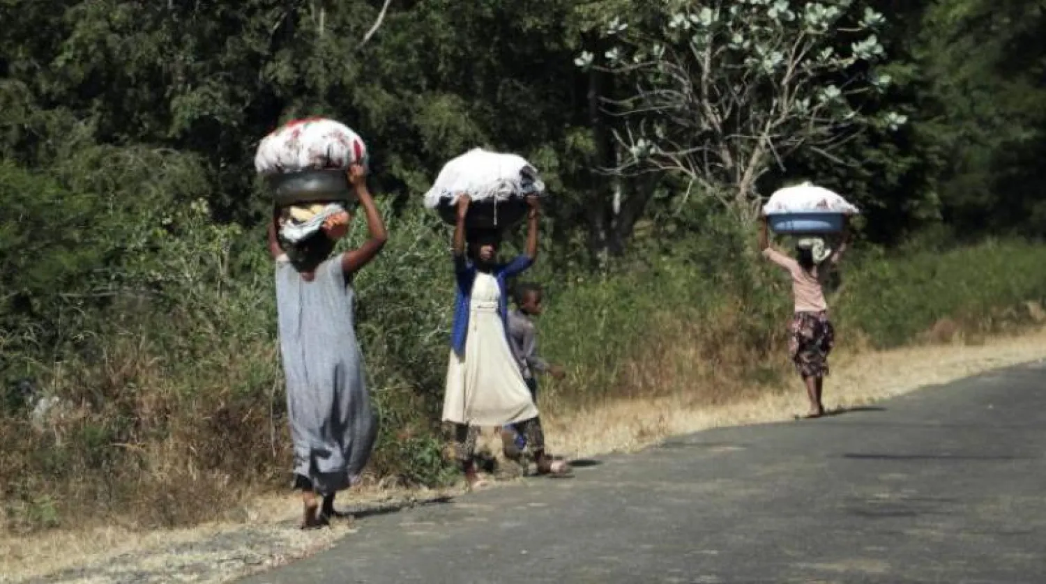 فتيات يحملن الملابس في بلدة سوروكا في منطقة أمهرة قرب الحدود مع تيغراي (رويترز)