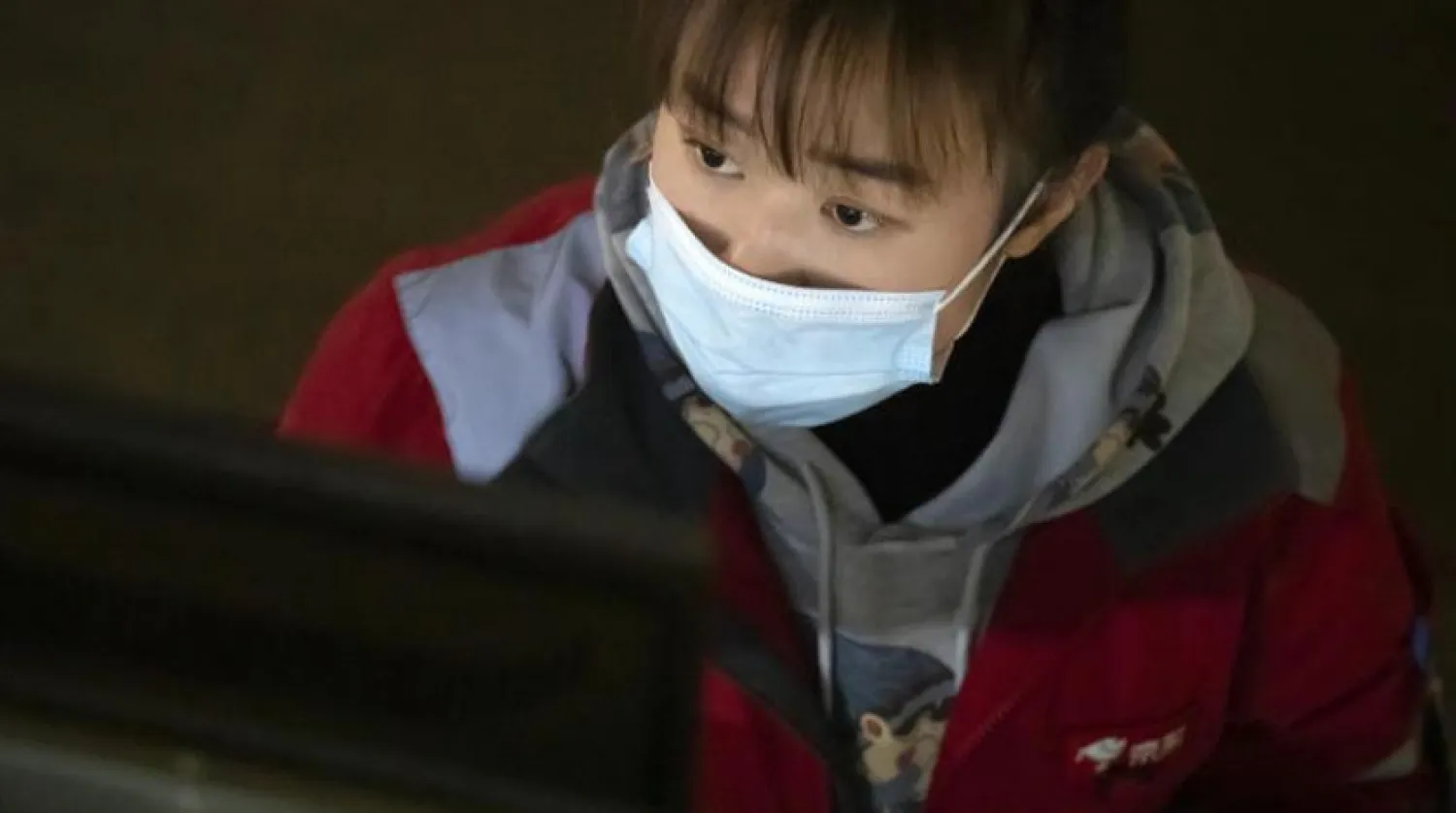 Çin'deki bir şirkette çalışan görevli, koronavirüsüne karşı korunmak için maske takıyor (AP)