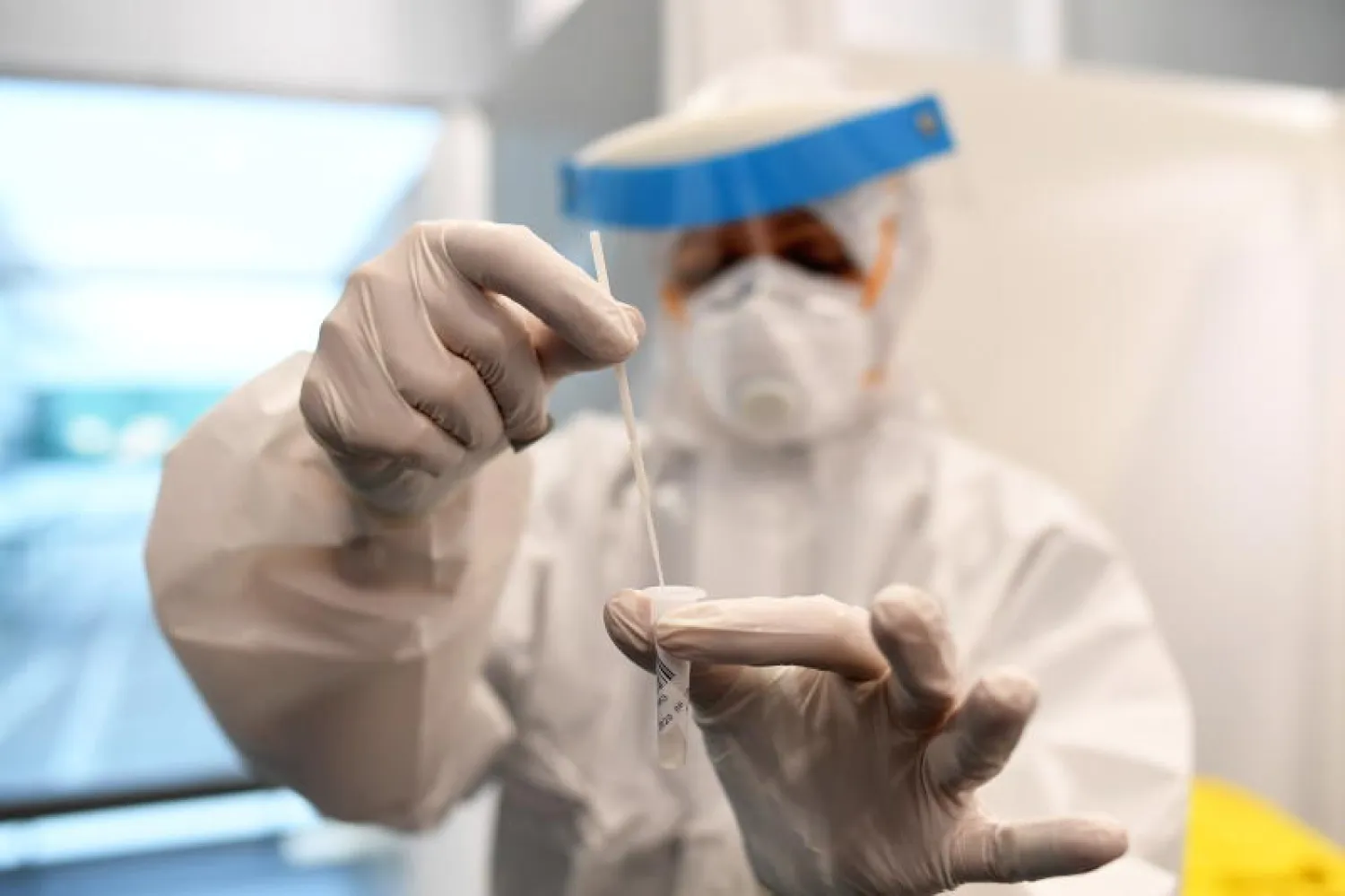 أحد أفراد الطاقم الطبي بمركز اختبار سريع لفحص كورونا (رويترز)