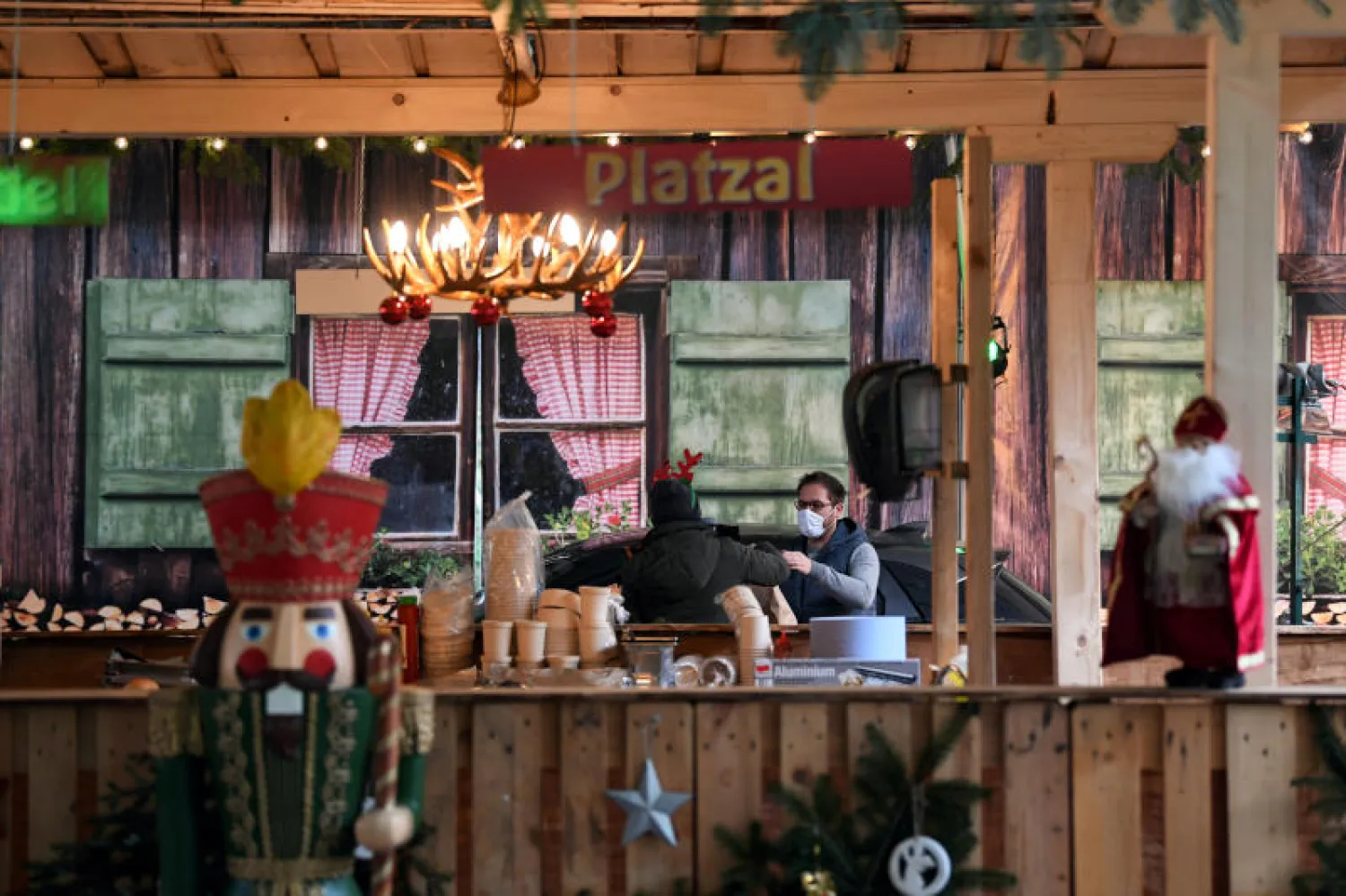 رجل يضع كمامة يشتري طعاماً من متجر في مدينة لاندشوت بمقاطعة بافاريا الألمانية (رويترز)