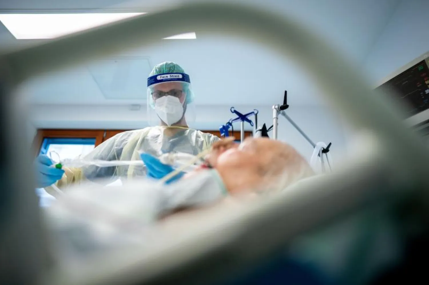 ممرض يهتم بمريض مصاب بكورونا داخل قسم العناية المركزة في مستشفى بألمانيا (د.ب.أ)