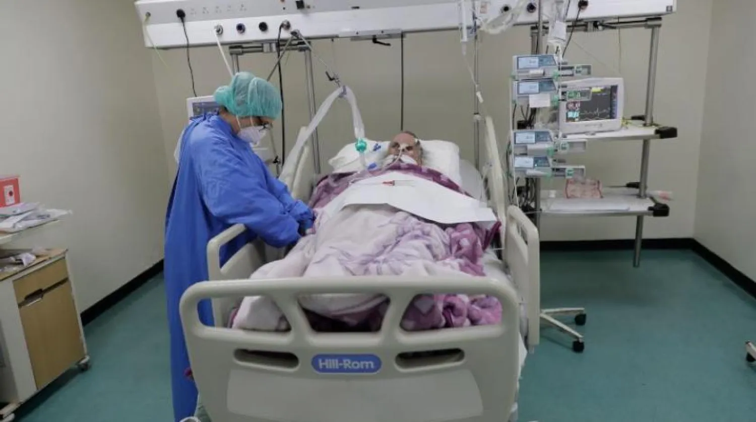 Beyrut'taki Refik Hariri Devlet Hastanesi'nde bir koronavirüs hastasıyla ilgilenen bir hemşire (AFP)