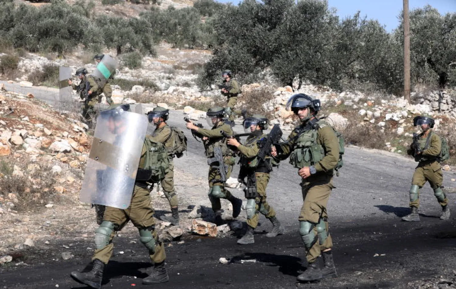 جنود إسرائيليون يتخذون مواقعهم خلال مواجهات مع متظاهرين فلسطينيين ضد المستوطنات الإسرائيلية بالقرب من مدينة نابلس (إ.ب.أ)