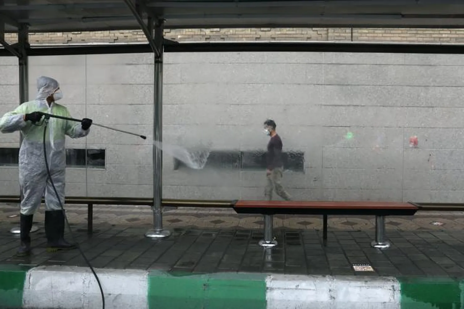 FILE PHOTO: A municipality worker wearing a protective suit, disinfects the area, amid the outbreak of the coronavirus disease (COVID-19), in Tehran, Iran November 11, 2020. Majid Asgaripour/WANA (West Asia News Agency) via REUTERS