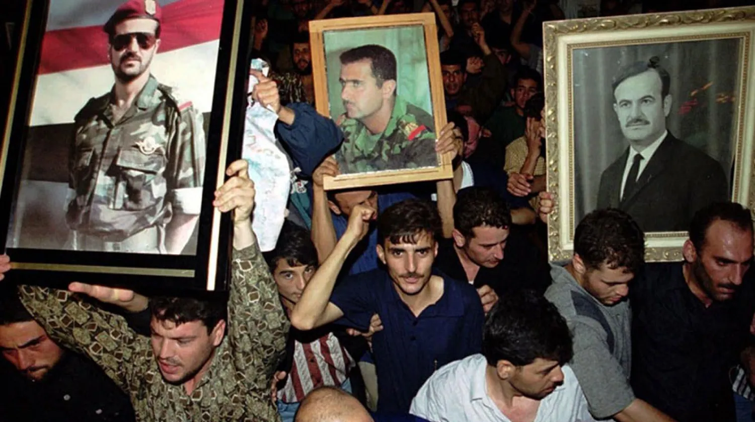 Şam'da 10 Haziran 2000'deki gösterilerde Hafız, Beşşar ve Basil Esed’in resimlerini taşıyan Suriyeliler (AP)