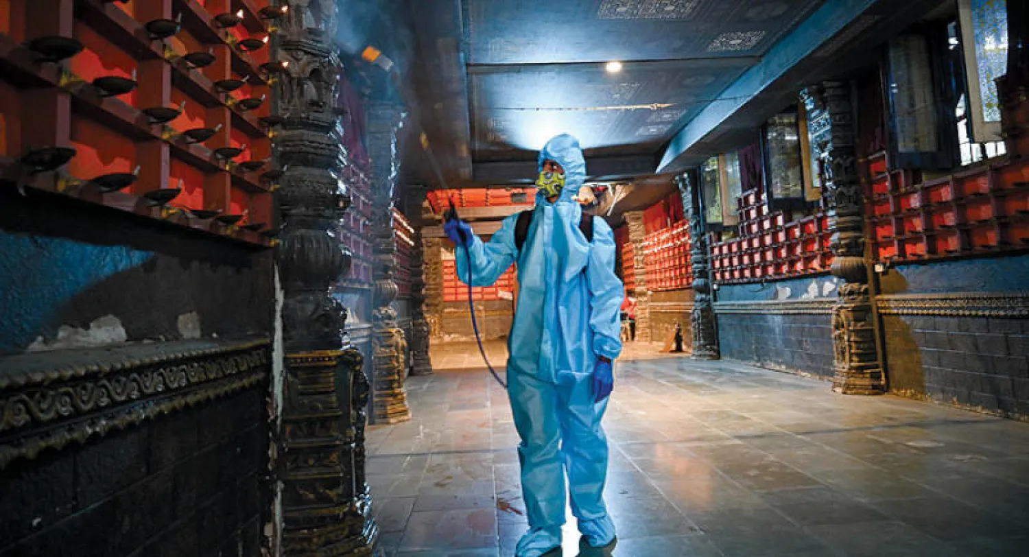 تعقيم أحد المعابد في الهند أمس (أ.ف.ب)