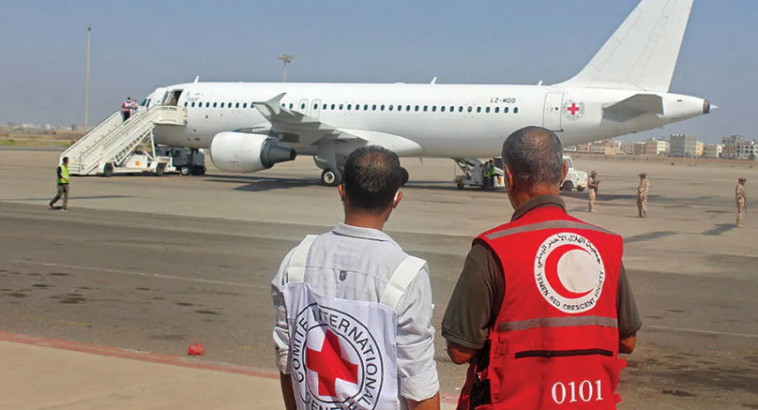 موظف في الهلال الأحمر اليمني وآخر من لجنة الصليب الأحمر الدولية في مطار عدن لتنفيذ صفقة تبادل الأسرى أكتوبر الماضي (أ.ف.ب)