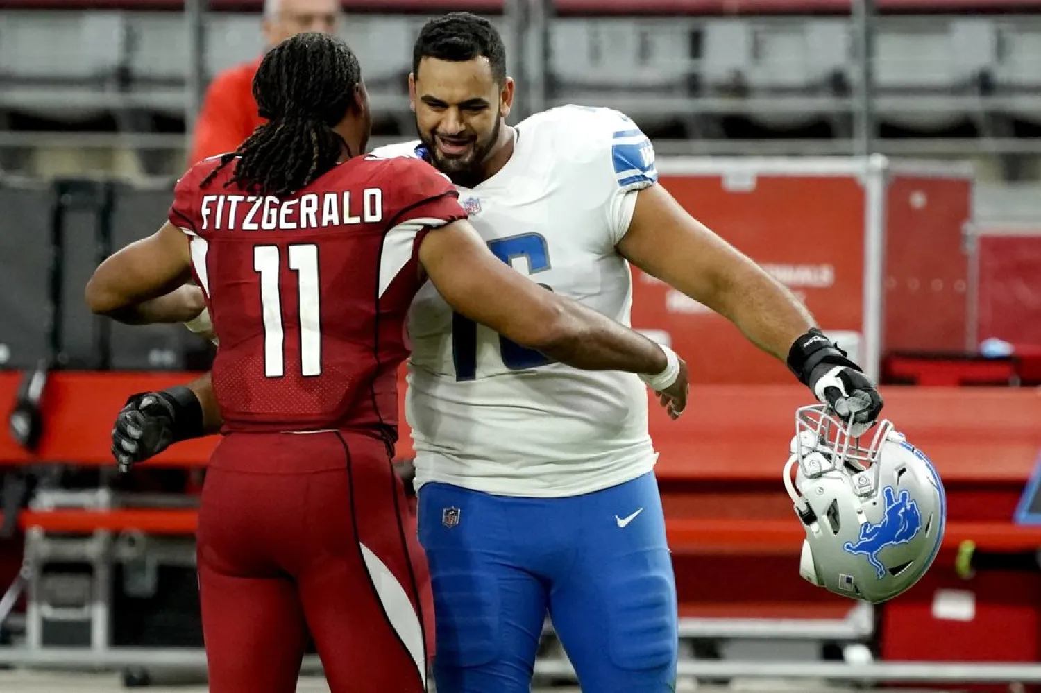 FILE- In a Sept. 27, 2020, file photo Arizona Cardinals wide receiver Larry Fitzgerald (11) greets Detroit Lions offensive guard Oday Aboushi (76) after an NFL football game in Glendale, Ariz. NFL players have kneeled during the anthem and have made stands to protest social injustice, but none have done it in quite the same way as Aboushi. He wants to use his platform to shed light on what he says is Israel's oppression of the Palestinians and to promote religious harmony as a Muslim with friends of different faiths. (AP Photo/Rick Scuteri, File)
