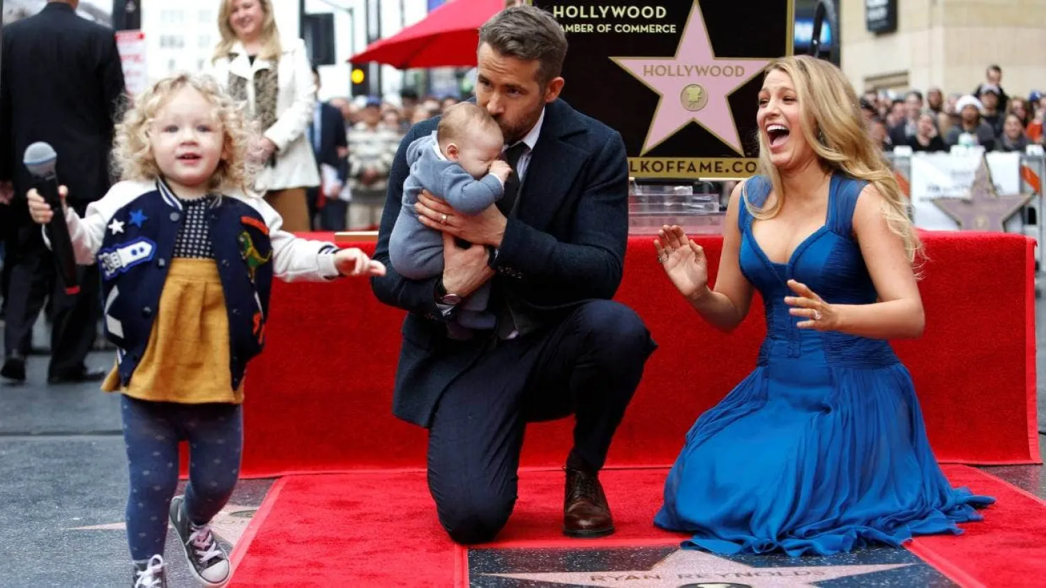 Actor Ryan Reynolds kisses his daughter Ines while posing by
his star with his actor wife Blake Lively and their daughter James on
the Hollywood Walk of Fame. MARIO ANZUONI/REUTERS
