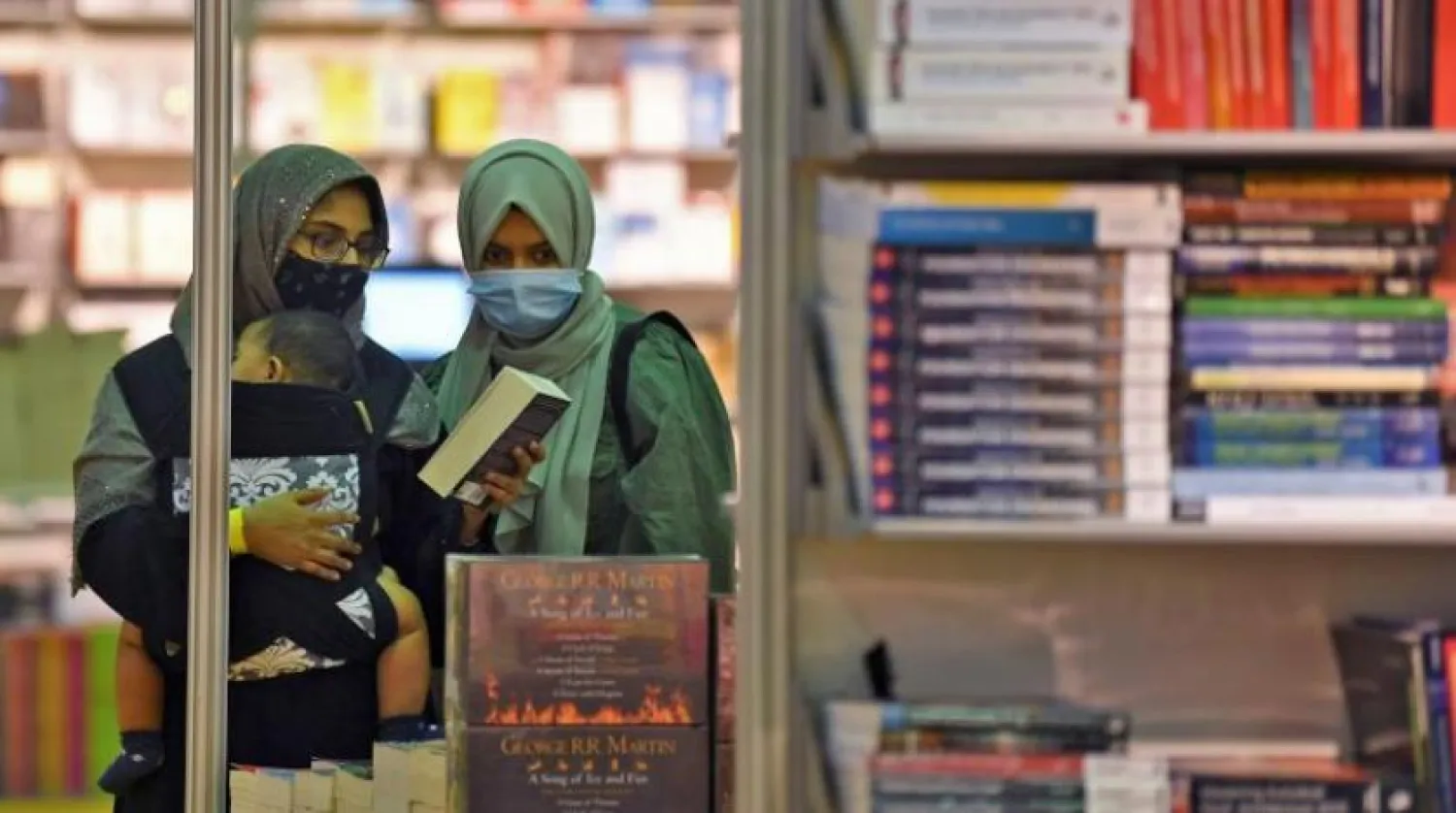 Kitap Fuarı’nda maskeleri ile dolaşan kadınlar (AFP)